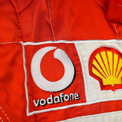 Close-up shot of Schumacher’s 2006 race suit, highlighting the detailed stitching, premium red material, and signature white branding elements.Bestracewear